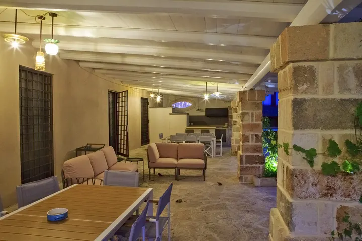 Il patio coperto di sera, con i salotti e i tavoli